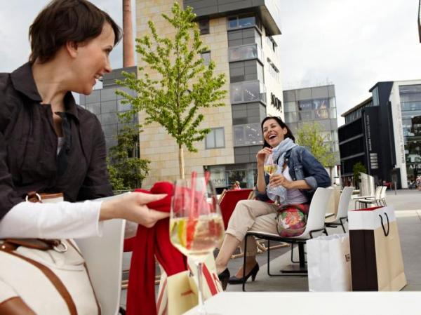 Shopping Outletcity Metzingen Frauen auf Außenterrasse von einem Restaurant